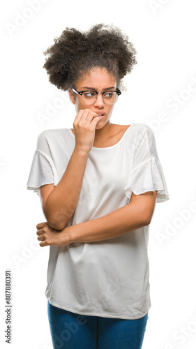 Young afro american woman wearing glasses over isolated background looking stressed and nervous with hands on mouth biting nails. Anxiety problem.