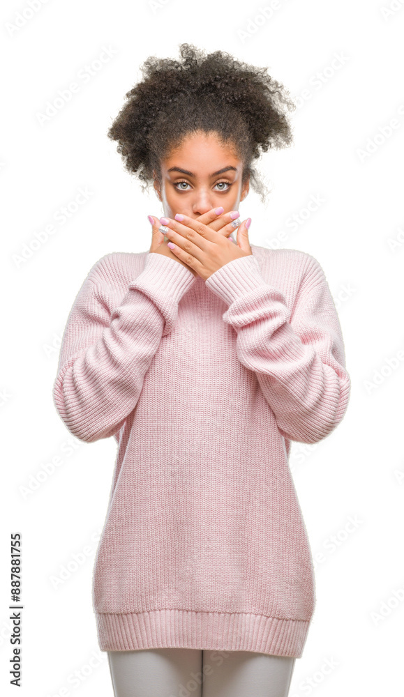Young afro american woman wearing winter sweater over isolated background shocked covering mouth with hands for mistake. Secret concept. Young afro american woman wearing winter sweater over isolated background shocked covering mouth with hands for mistake. Secret concept.