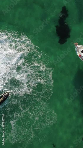 A man flies on a FlyBoard. Aerial top down view. Water extreme sport, azure summer sea with outdoors active people enjoying water sports. Flyboarding and seariding, Recreation and sports concepts. photo