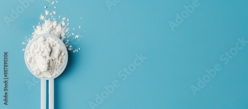 Obraz na płótnie White powder in a plastic spoon arranged on a blue background in a composition ideal for adding text suitable for display with copy space image w salonie