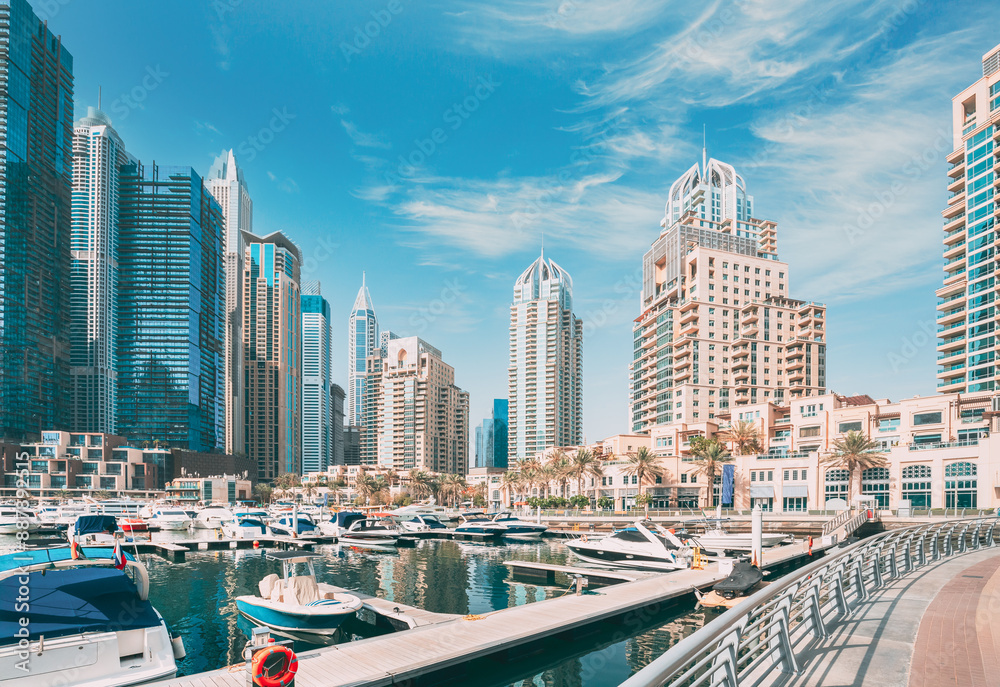 Dubai Marina Port, UAE, United Arab Emirates. Yachts are moored at city pier, jetty in Dubai Marina. Cityscape skyline. Skyscrapers in Dubai