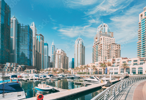 Obraz na płótnie Dubai Marina Port, UAE, United Arab Emirates. Yachts are moored at city pier, jetty in Dubai Marina. Cityscape skyline. Skyscrapers in Dubai w salonie