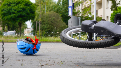 a bicycle helmet knocked over on the sidewalk, a fairy bicycle overturned close to it