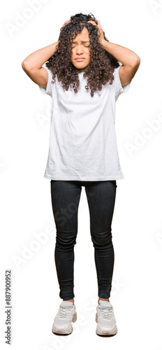 Fotografie Young beautiful woman with curly hair wearing white t-shirt suffering from headache desperate and stressed because pain and migraine