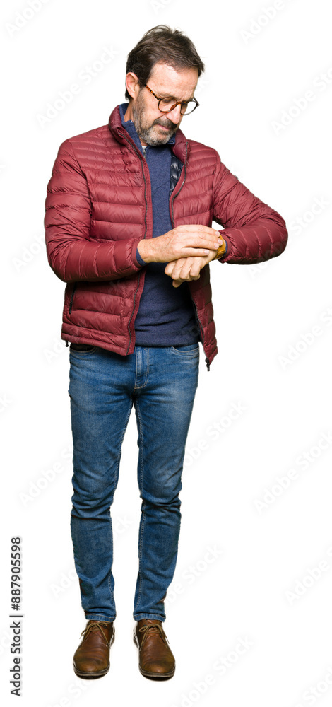 Middle age handsome man wearing glasses and winter coat Checking the time on wrist watch, relaxed and confident Middle age handsome man wearing glasses and winter coat Checking the time on wrist watch, relaxed and confident