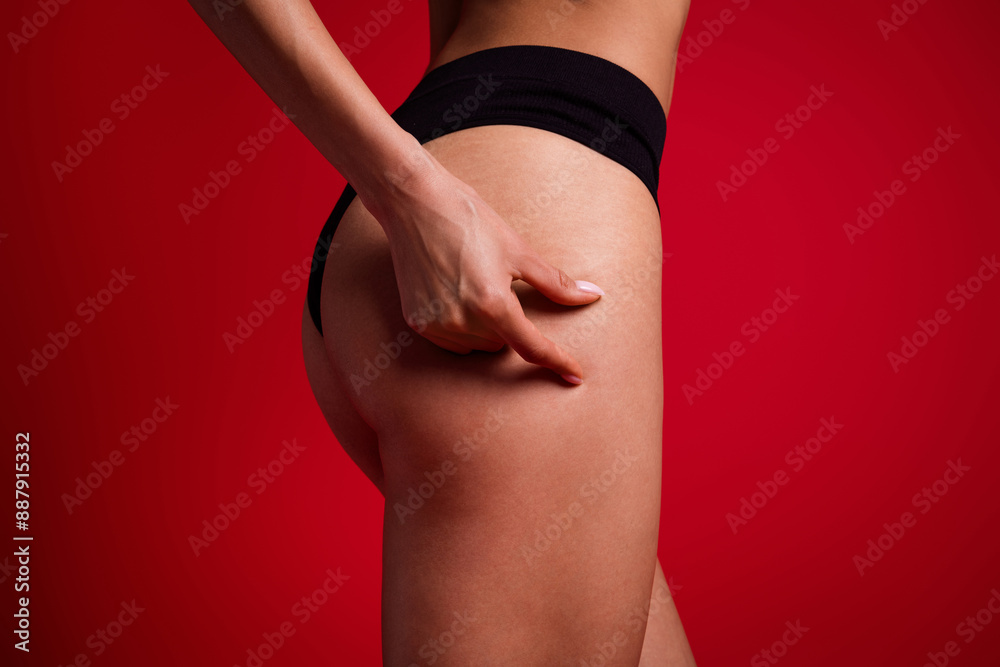 Fototapeta premium Cropped photo of attractive young woman touch skin booty cellulitis dressed black lingerie no filter isolated on red color background