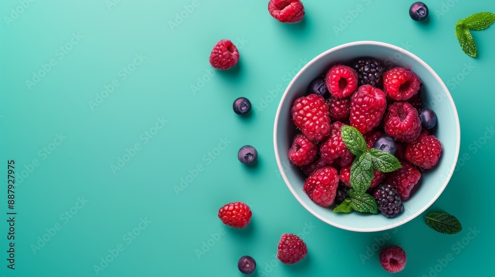 Fresh mixed berries in a bowl on a turquoise background Fresh mixed berries in a bowl on a turquoise background