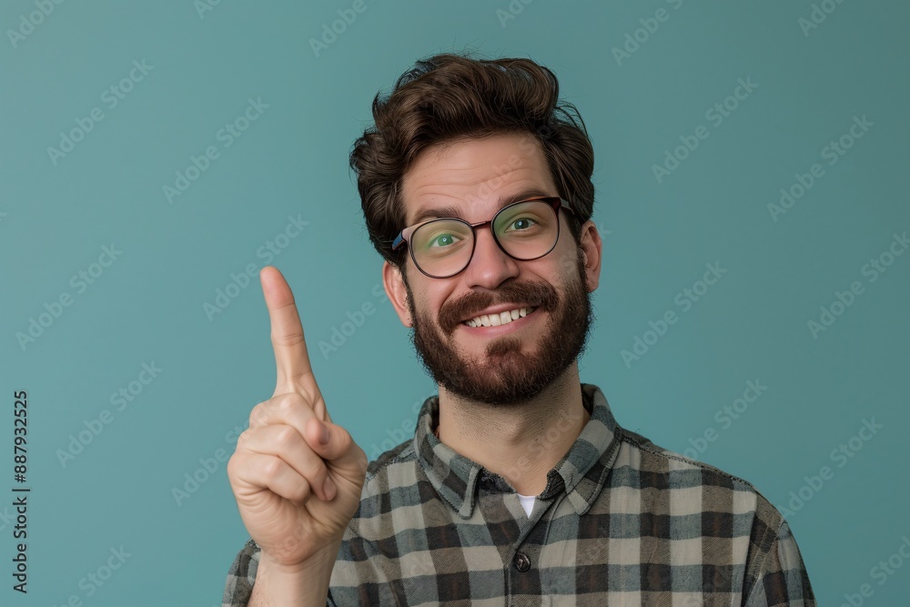 a man with glasses and a beard pointing up