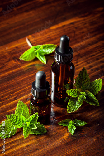 Obraz na płótnie Fresh mint leaves, essential oil on wooden table w salonie
