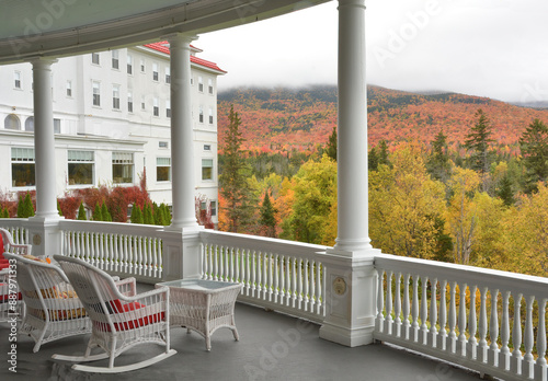 Relaxing and restful scene at the elegant Mount Washington Grand Hotel. Stunning view of mountains and vibrant fall foliage from veranda of this historic hotel in the White Mountains of New Hampshire.
