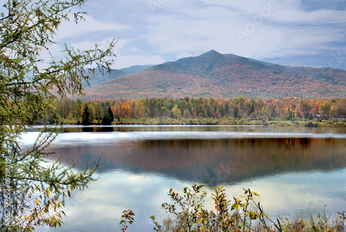 Autumn scene in the White Mountains. Colorful fall foliage with reflection of sky and Owl's Head Mountain on calm surface of pond in Jefferson, New Hampshire. photo