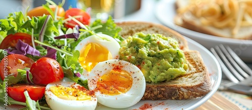 Nutritious breakfast consisting of a boiled egg guacamole toast and fresh salad with room for adding desired text or images. Copy space image. Place for adding text and design