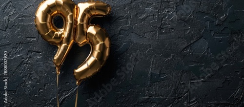 Anniversary or birthday card with the number 95 in a golden foil balloon style set against a black concrete backdrop for an anniversary banner with a copy space image photo