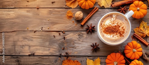 Autumn vibes with a pumpkin spiced latte in a white cup on a rustic wooden backdrop featuring pumpkins cinnamon and spices perfect for a copy space image photo