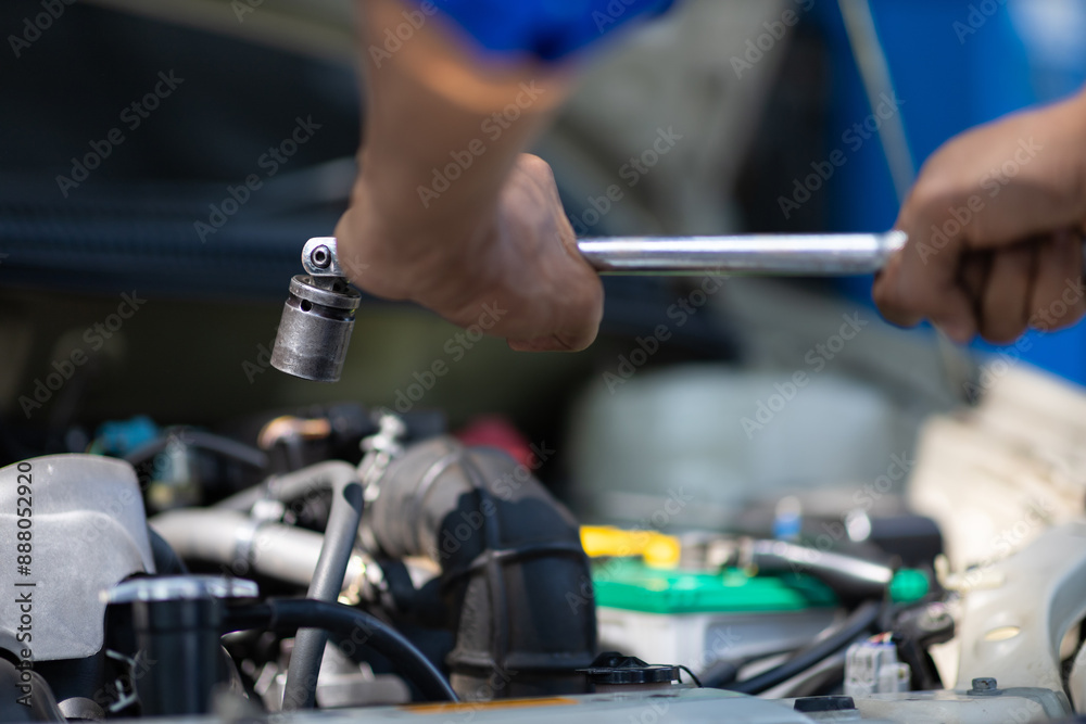Auto mechanic repairs engine and uses wrench to tighten car screws. Auto mechanic repairs engine and uses wrench to tighten car screws.