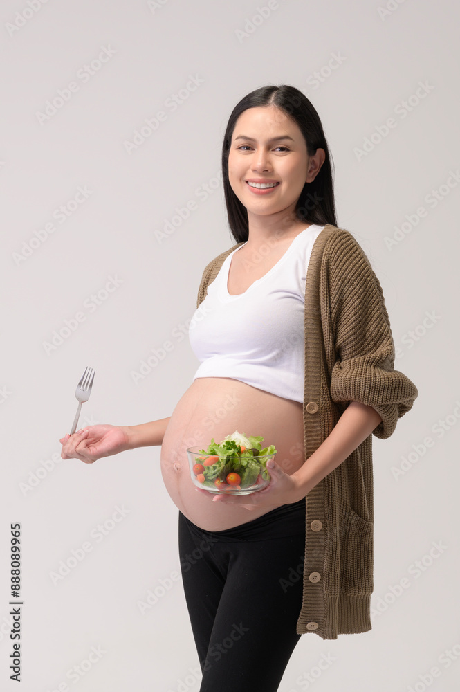Portrait of Beautiful pregnant woman eating salad over white background studio, health and maternity concept. Portrait of Beautiful pregnant woman eating salad over white background studio, health and maternity concept.