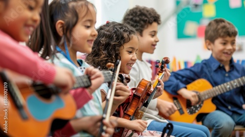 Diverse group of elementary school students happily playing string instruments during music lesson