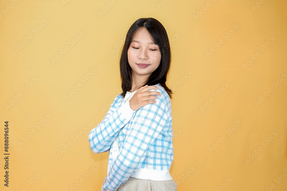 Happy mindful thankful young woman holding hands on chest smiling isolated on yellow background feeling no stress, gratitude, mental health balance, peace of mind concept. Happy mindful thankful young woman holding hands on chest smiling isolated on yellow background feeling no stress, gratitude, mental health balance, peace of mind concept.