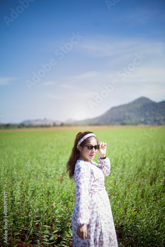 Beautiful pregnant woman in flower farm with mountains in the background