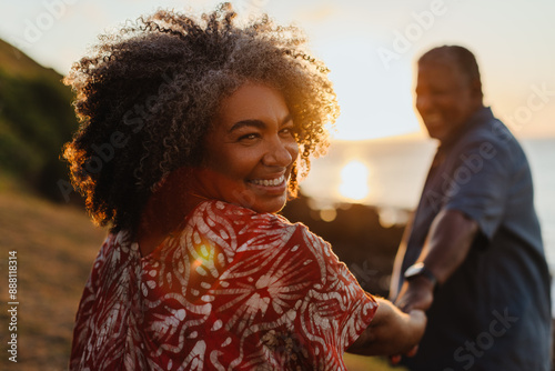 Senior woman enjoying a walk at sunset, celebrating longevity and vitality with her partner photo