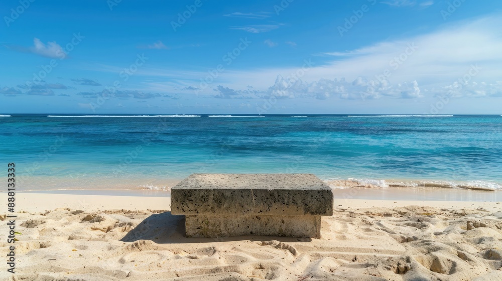 Fototapeta premium The clear blue tropical sea and soft sand create a serene backdrop for an abstract stone podium on the beach. 