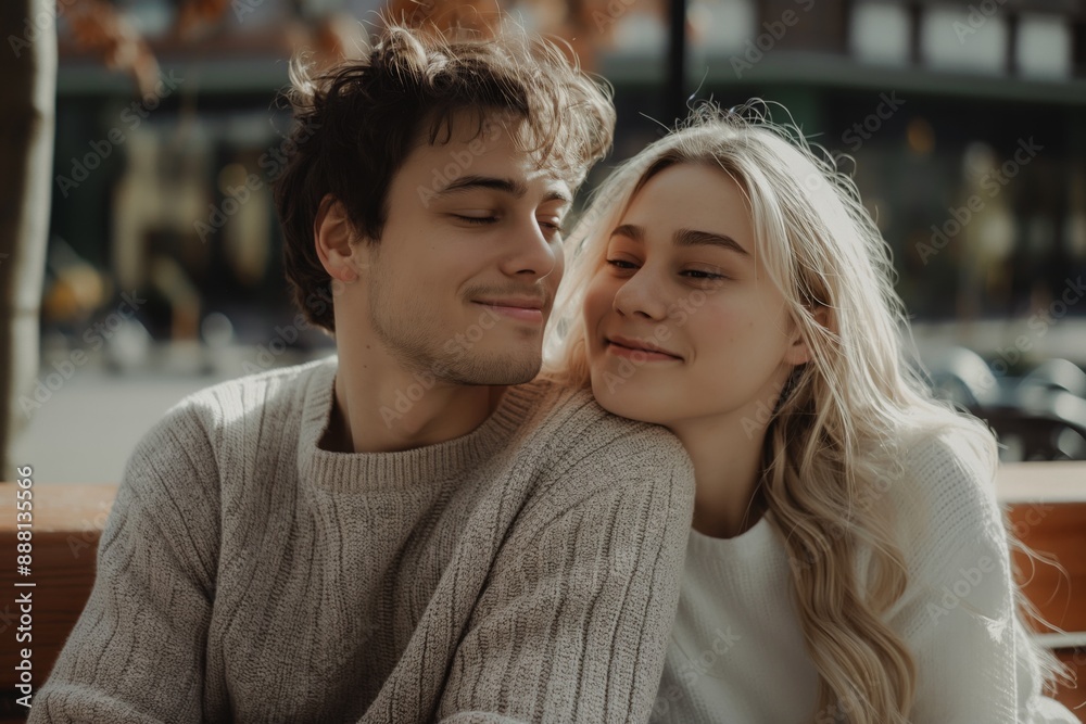 Young couple in love sitting together on bench, outdoor romance concept Young couple in love sitting together on bench, outdoor romance concept