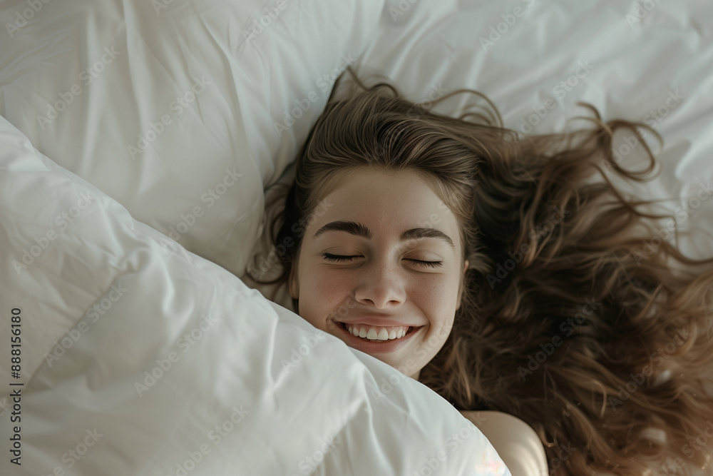 A happy girl lies on the bed covered with a blanket. A healthy sleep. A happy girl lies on the bed covered with a blanket. A healthy sleep.