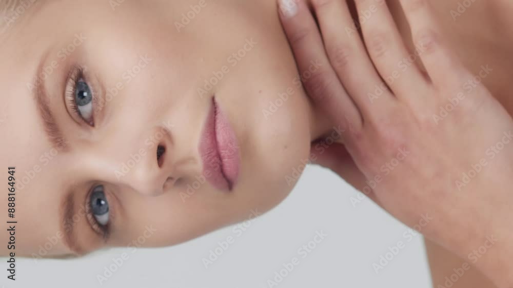 Studio portrait of young, beautiful and natural blond woman applying skin care cream. Vertical video. the concept of face lifting, cosmetics and make-up. Studio portrait of young, beautiful and natural blond woman applying skin care cream. Vertical video. the concept of face lifting, cosmetics and make-up.