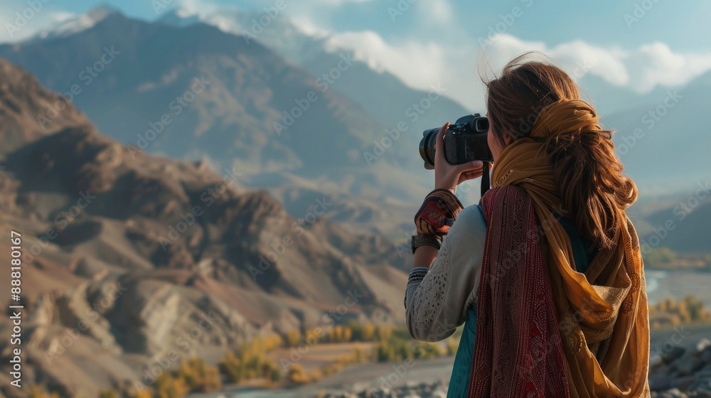 modern woman from side back, in an outdoor setting, with mountains around her , taking pictures of the scenery modern woman from side back, in an outdoor setting, with mountains around her , taking pictures of the scenery
