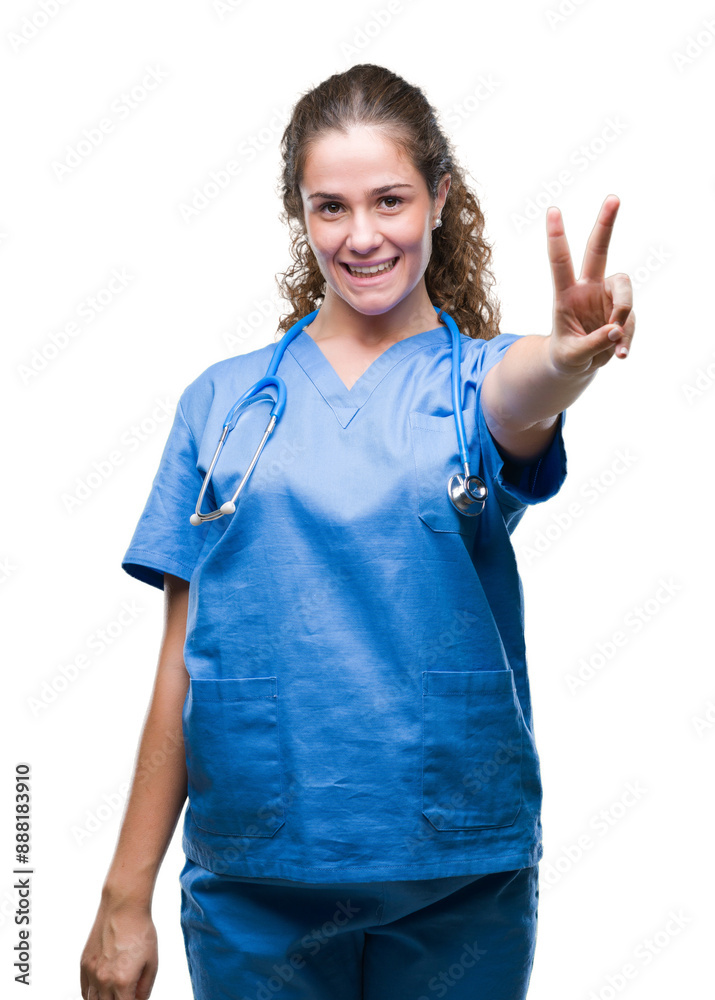 Young brunette doctor girl wearing nurse or surgeon uniform over isolated background showing and pointing up with fingers number two while smiling confident and happy. Young brunette doctor girl wearing nurse or surgeon uniform over isolated background showing and pointing up with fingers number two while smiling confident and happy.