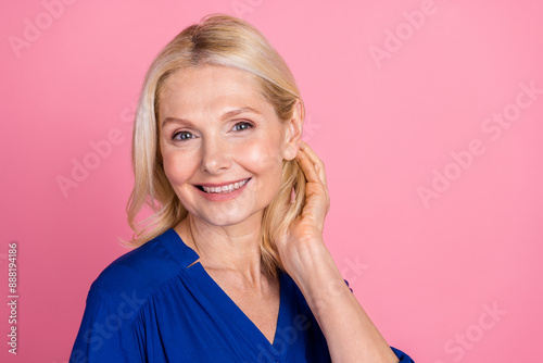 Photo portrait of attractive retired woman tuck hair behind ear dressed stylish blue clothes isolated on pink color background