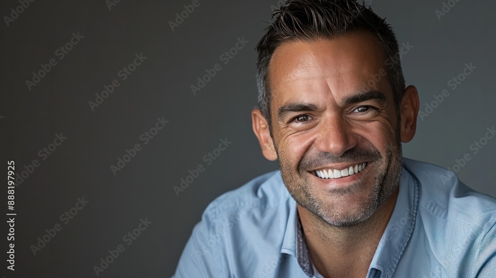 Fototapeta premium Confident businessman with short dark hair smiles in a casual headshot portrait