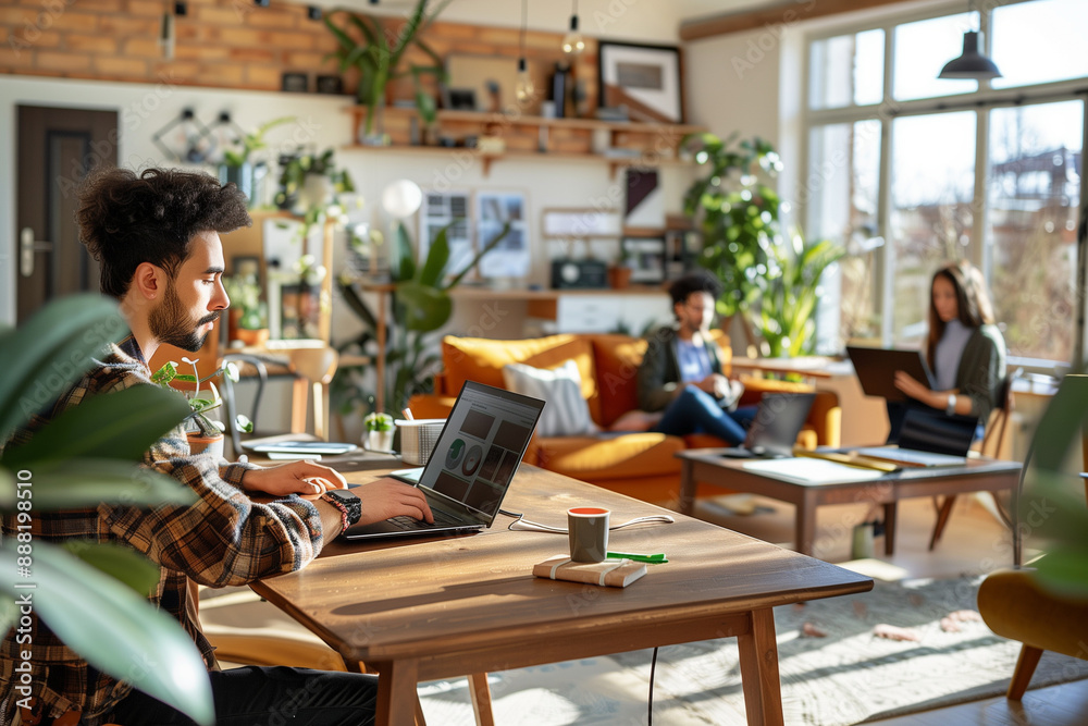 A man is working on a laptop in a living room with a couch and a potted plant A man is working on a laptop in a living room with a couch and a potted plant