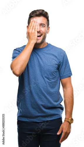 Young handsome man over isolated background covering one eye with hand with confident smile on face and surprise emotion.