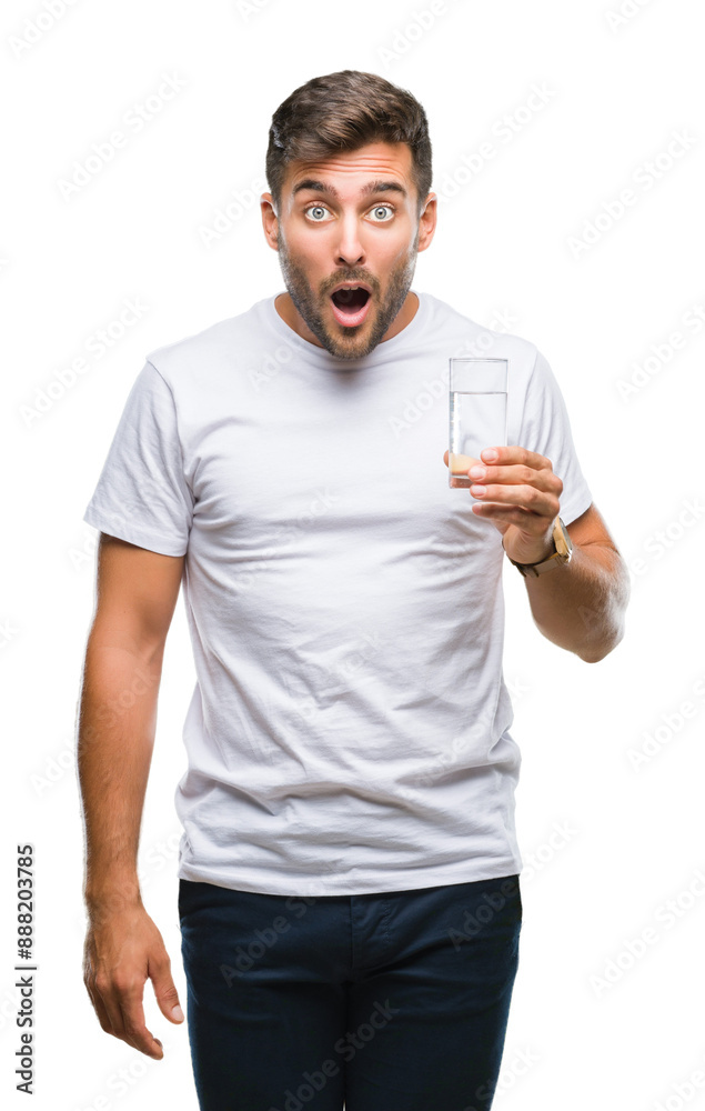 Young handsome man drinking glass of water over isolated background scared in shock with a surprise face, afraid and excited with fear expression Young handsome man drinking glass of water over isolated background scared in shock with a surprise face, afraid and excited with fear expression