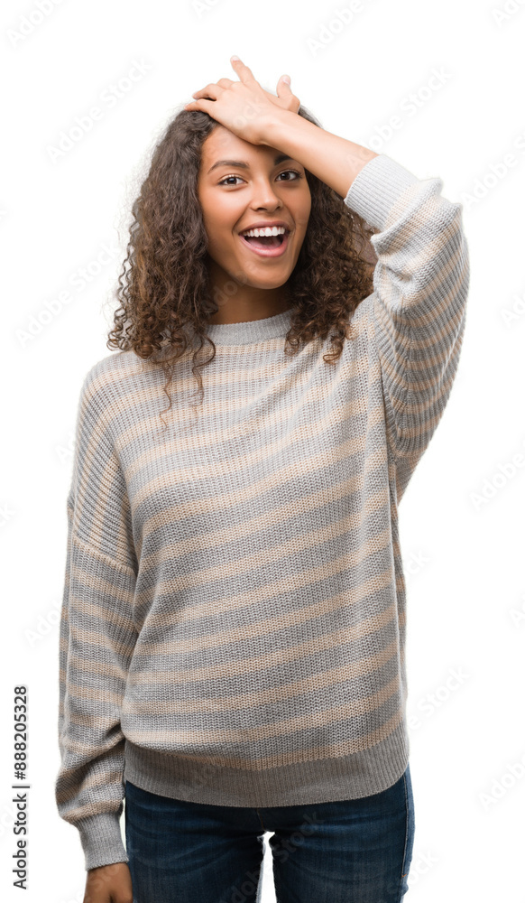 Beautiful young hispanic woman wearing stripes sweater surprised with hand on head for mistake, remember error. Forgot, bad memory concept. Beautiful young hispanic woman wearing stripes sweater surprised with hand on head for mistake, remember error. Forgot, bad memory concept.