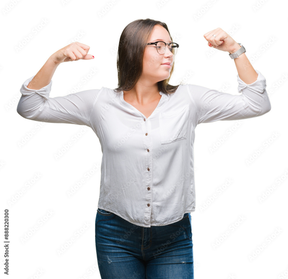 Young caucasian beautiful business woman wearing glasses over isolated background showing arms muscles smiling proud. Fitness concept. Young caucasian beautiful business woman wearing glasses over isolated background showing arms muscles smiling proud. Fitness concept.