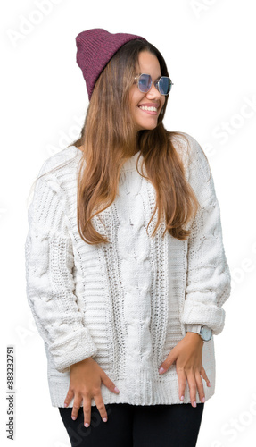 Young beautiful brunette hipster woman wearing sunglasses over isolated background looking away to side with smile on face, natural expression. Laughing confident.