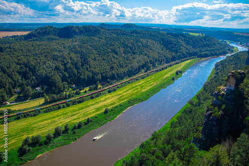 Foto a narrow river flows in the mountains, many green trees, blue sky, clouds