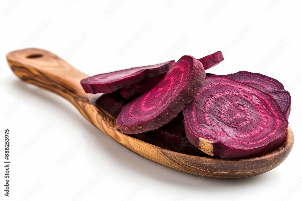 Obraz premium Dehydrated beet slices on wooden spoon with white backdrop