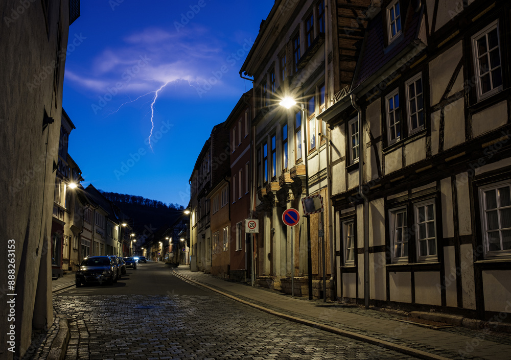 Street alley in the small town of Schwabisch Hall, with houses and buildings with typical German architecture and street lanterns, at night.