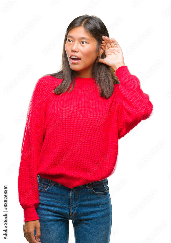Young asian woman wearing winter sweater over isolated background smiling with hand over ear listening an hearing to rumor or gossip. Deafness concept. Young asian woman wearing winter sweater over isolated background smiling with hand over ear listening an hearing to rumor or gossip. Deafness concept.