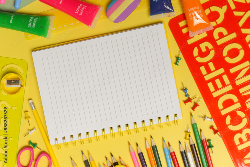 Back to school concept with variety of office and school supplies on yellow background. Back to school concept with variety of office and school supplies on yellow background.