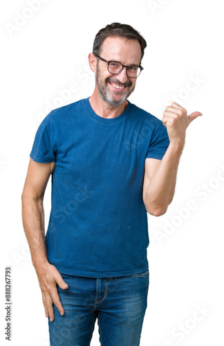 Handsome middle age hoary senior man wearin glasses over isolated background smiling with happy face looking and pointing to the side with thumb up.