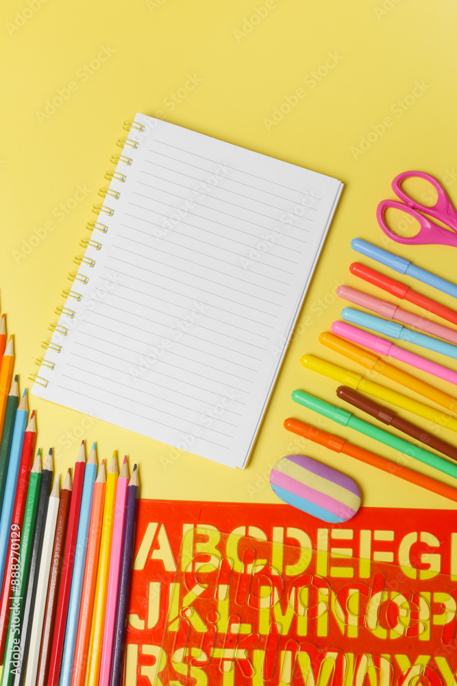 Back to school concept with variety of office and school supplies on yellow background. Back to school concept with variety of office and school supplies on yellow background.