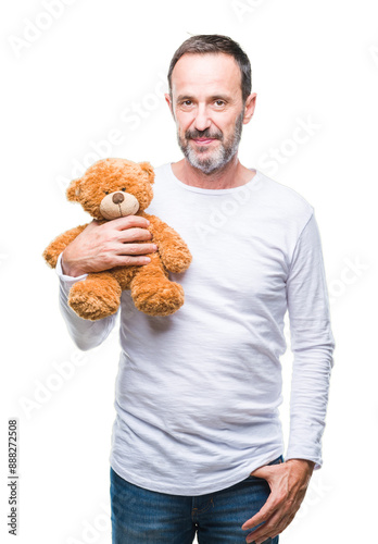 Middle age senior hoary man holding teddy bear over isolated background with a confident expression on smart face thinking serious