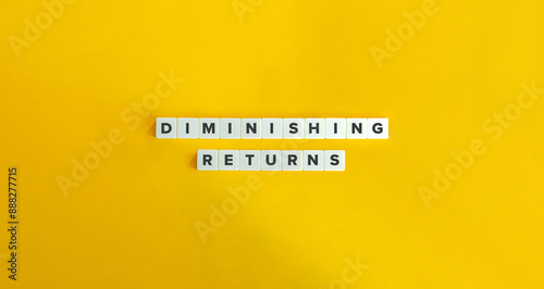 Diminishing Returns Term and Text on Block Letter Tiles against Yellow Background. 
