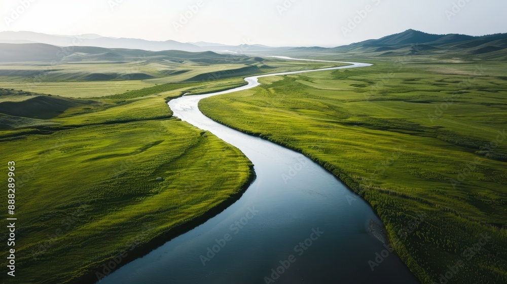 This aerial image showcases a meandering river cutting through an expansive green landscape, symbolizing tranquility and the serene beauty of untouched natural environments. This aerial image showcases a meandering river cutting through an expansive green landscape, symbolizing tranquility and the serene beauty of untouched natural environments.