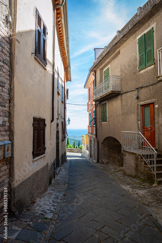 Narrow alley in the small medieval town of Fosdinovo in Tuscany, Italy with view at the Mediterranean Sea photo