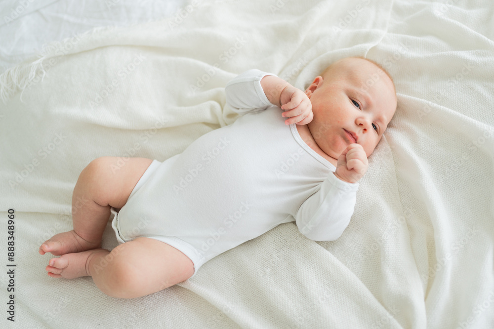 Happy baby. Cute little newborn girl with smiling face lying on bed in bedroom. Infant baby resting playing lying down on white blanket at home. Motherhood happy child childcare concept Happy baby. Cute little newborn girl with smiling face lying on bed in bedroom. Infant baby resting playing lying down on white blanket at home. Motherhood happy child childcare concept